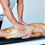 **

A fully clothed sports massage therapist, wearing modest athletic wear, demonstrating a petrissage technique on a male athlete's calf muscle. The athlete is lying face down on a massage table in a clean, well-lit clinic setting. Focus on the therapist's hands and the athlete's leg. Safe for work, appropriate content, professional, perfect anatomy, correct proportions, natural pose, well-formed hands, proper finger count, natural body proportions.

**